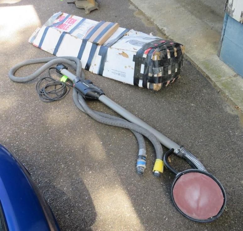 An angled sander tool with hoses.