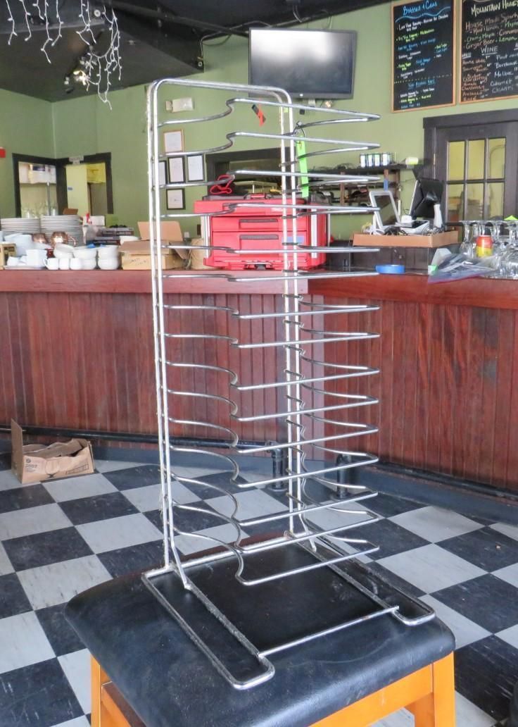 Chrome wire rack with multiple shelves, in a restaurant setting.
