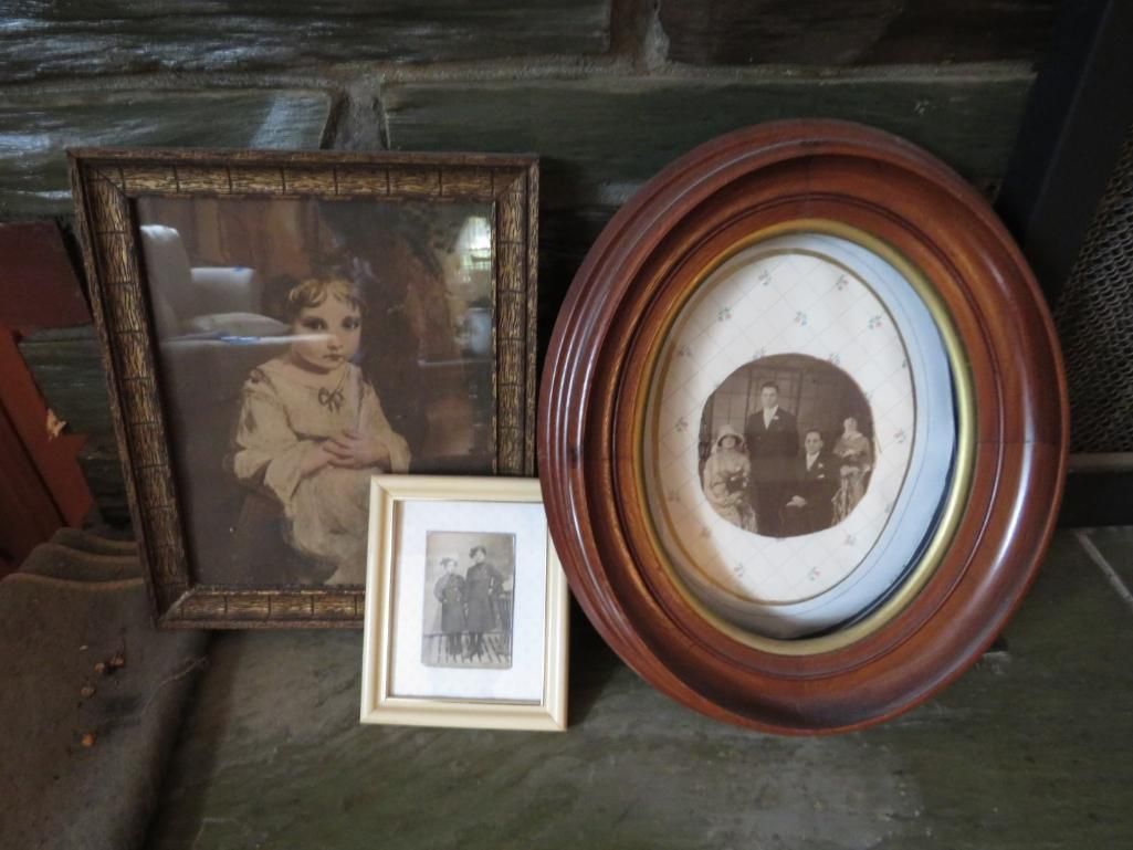 Three framed vintage photographs on a stone surface: a child, a group, and a couple.