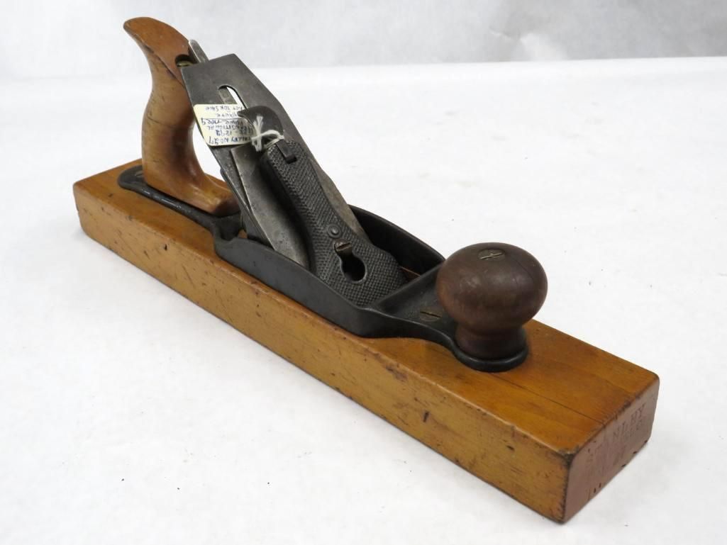 Wooden hand plane with a dark iron blade and handle.