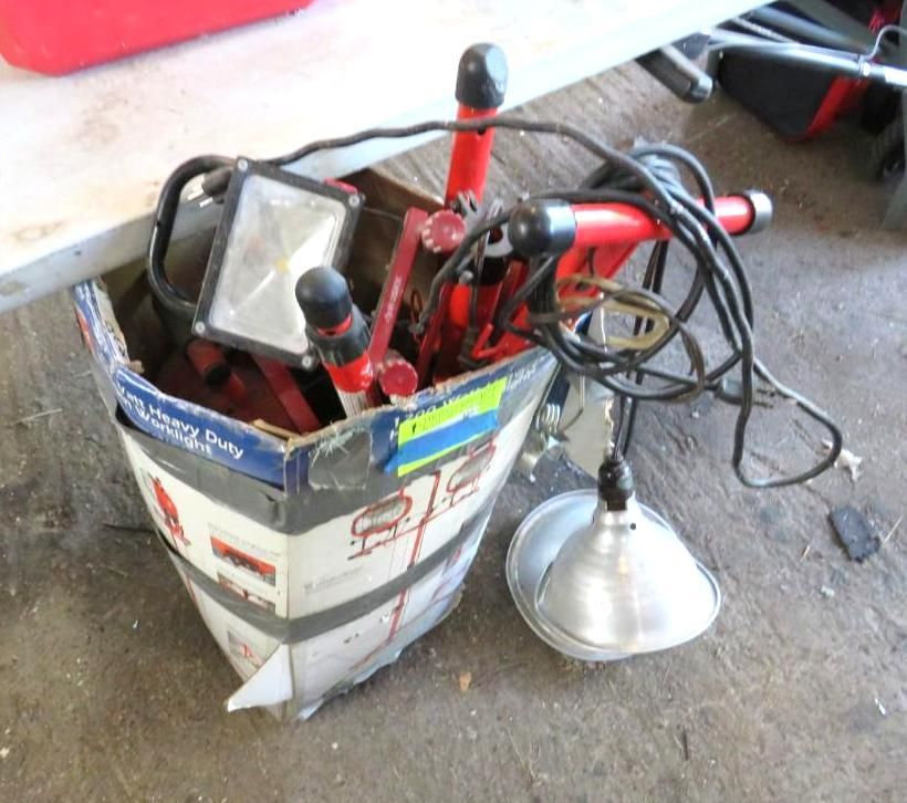 A cardboard container filled with red work lights and a silver lamp.