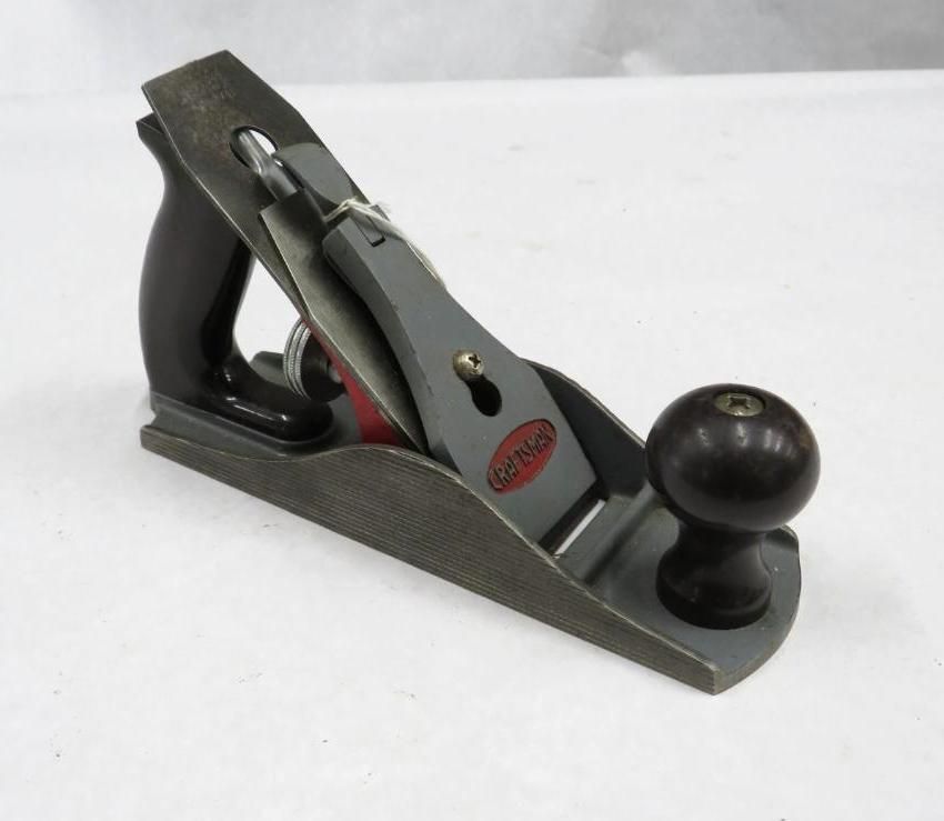 Gray and black hand plane with wooden handle and knob.