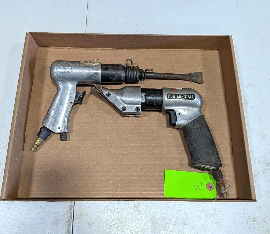 Two pneumatic tools in a cardboard box, one silver and black with a trigger handle, one compact gray drill.