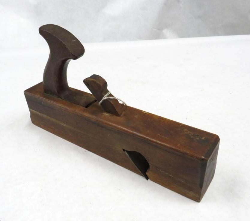 Wooden rabbet plane, brown, with handle and blade, on a white surface.