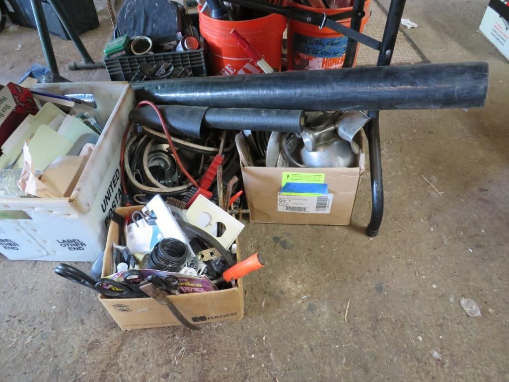 Several boxes and containers holding tools and equipment on a concrete floor.