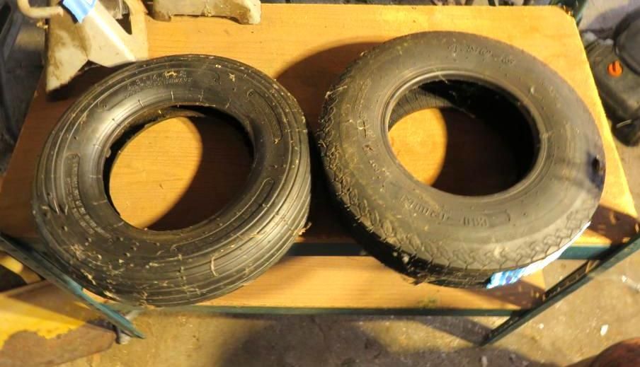 Two black tires on a wooden table.