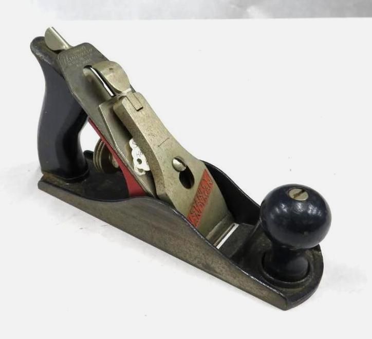 Hand plane tool on a white surface, black and grey with a red stripe.