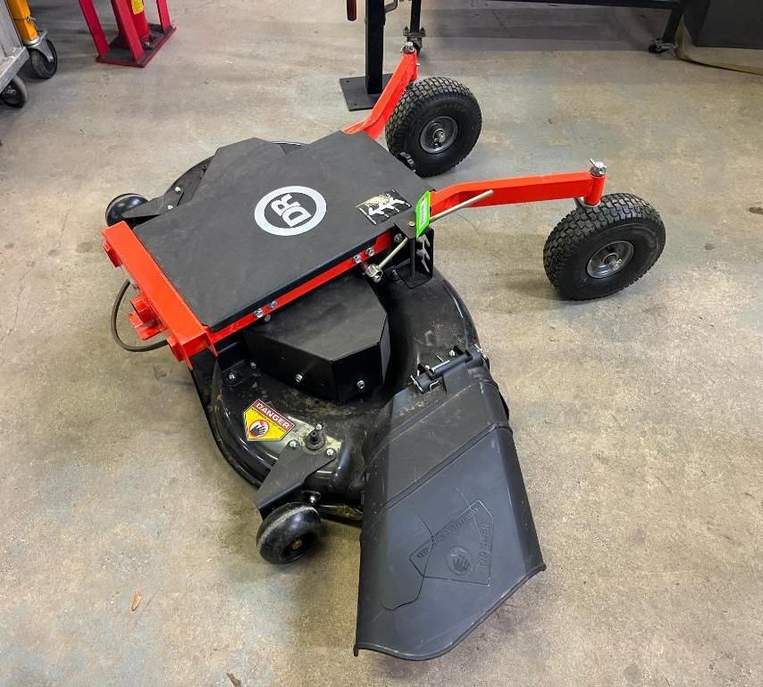 Red and black custom robot lawn mower with large wheels on a concrete floor.