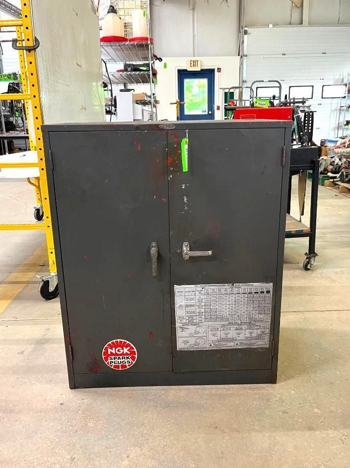 Gray metal cabinet with doors, factory setting.