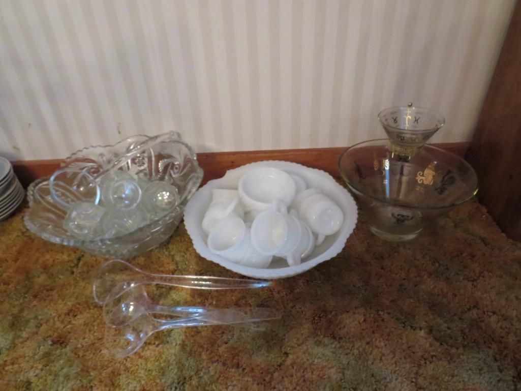 Glass punch bowl set on a rug. Includes a large bowl, cups, ladle, and serving bowl.