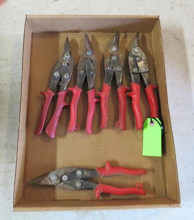 Box of red-handled metal shears. Some have green tag attached.