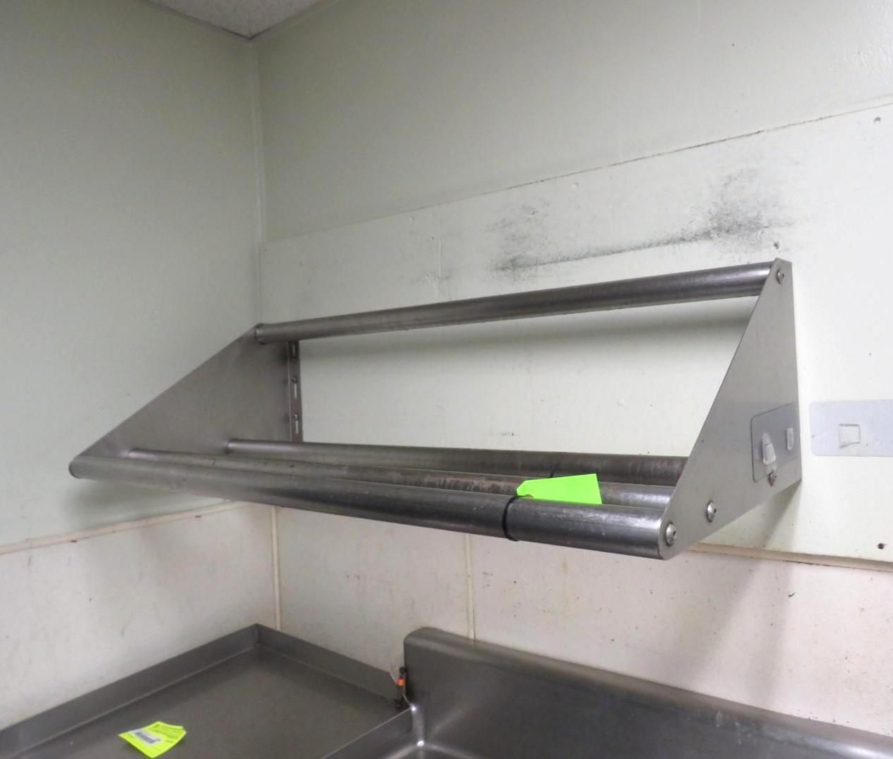 Stainless steel shelf above a kitchen counter, mounted to a white wall.