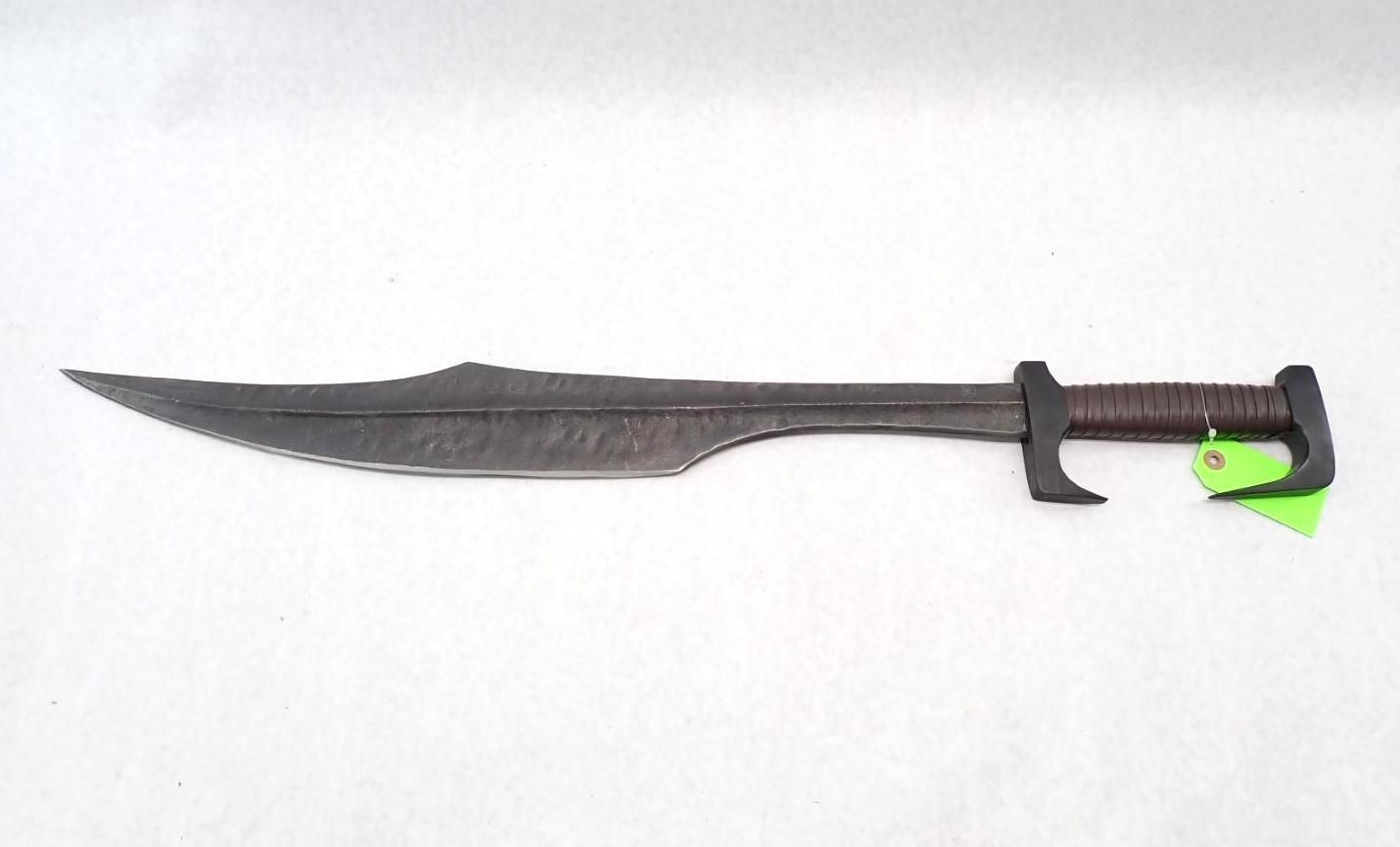 Dark metal sword with a curved blade and a leather-wrapped handle on a white background.