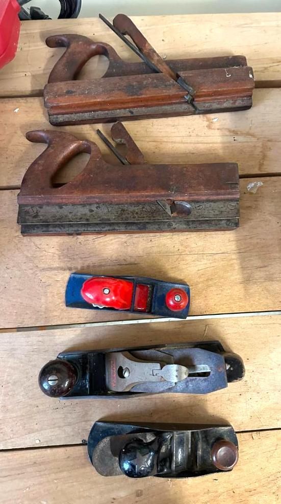 Wooden hand planes of various sizes on a wooden surface.