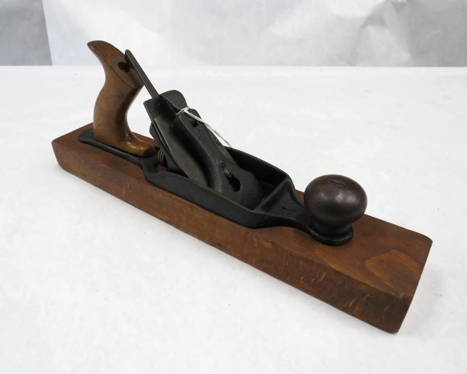 Wood smoothing plane with wooden body and metal blade.