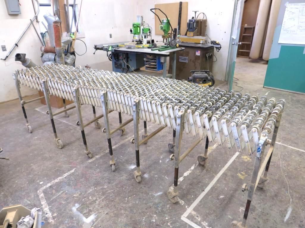 Expandable metal conveyor in a workshop with tools.
