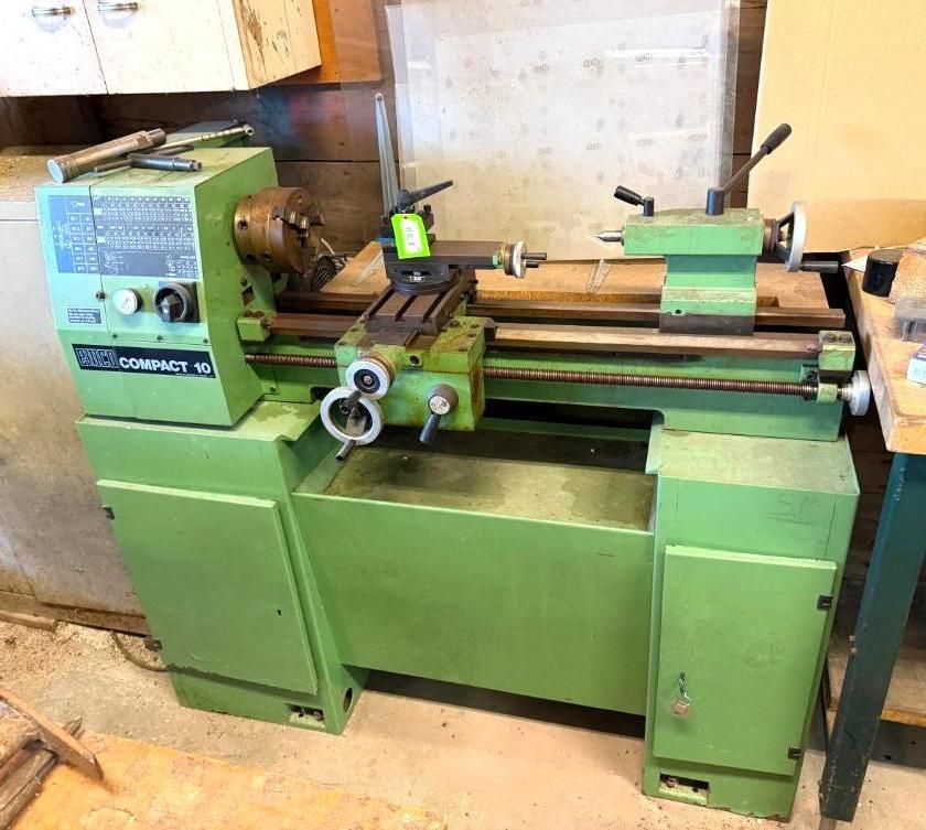 Green metal lathe in a workshop, used for shaping materials.