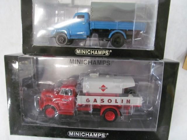 Two Minichamps model trucks in boxes: blue flatbed and red gasoline tanker.