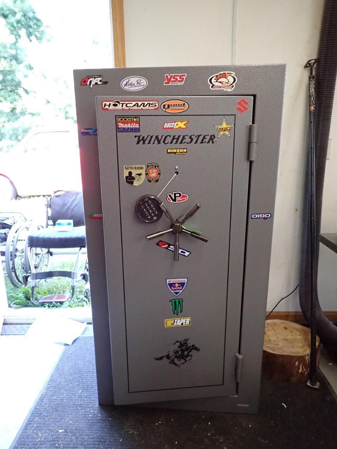 A gray Winchester gun safe covered in stickers.