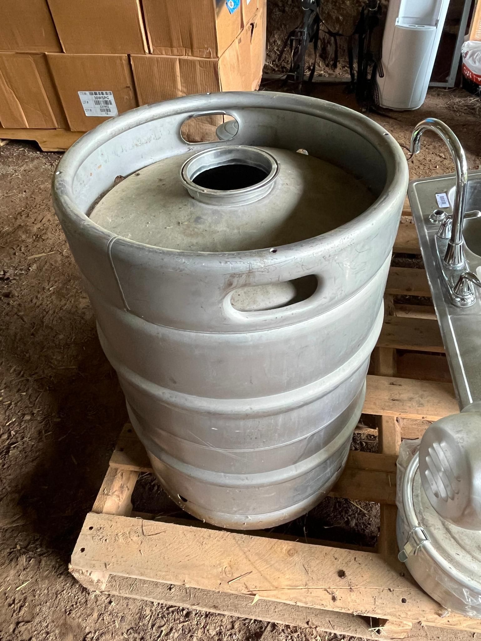 Silver beer keg on a wooden pallet.