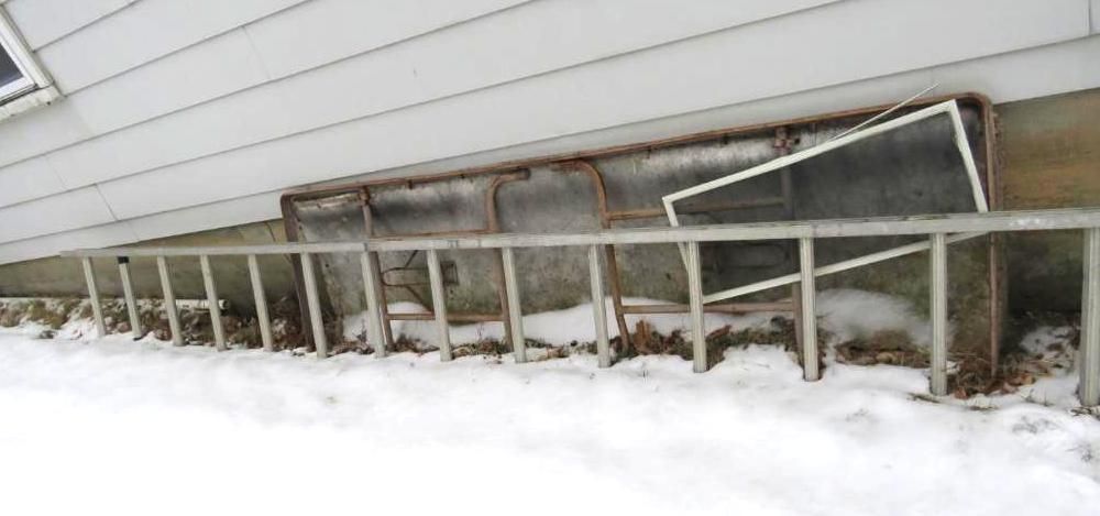 A metal ladder, a folding table, and a window screen.