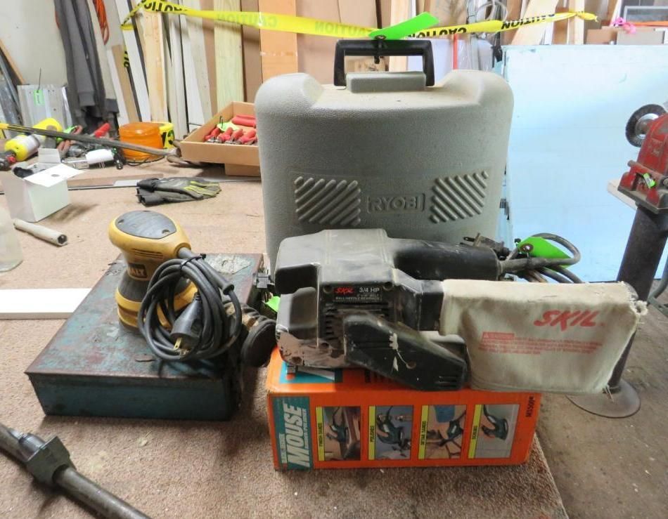 Assortment of power tools, including a sander, dust collector, and a box of sanding accessories.
