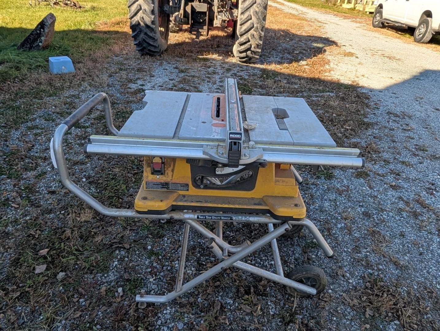 Portable table saw on a stand in a gravel driveway