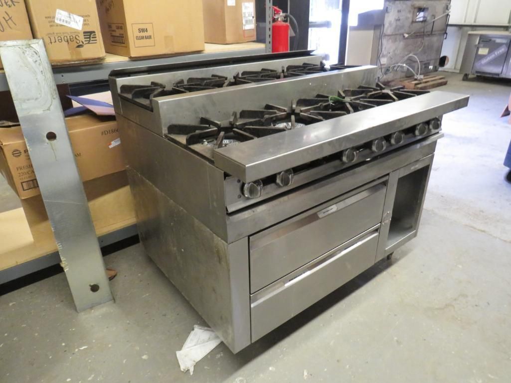 Stainless steel commercial gas range with burners and oven.