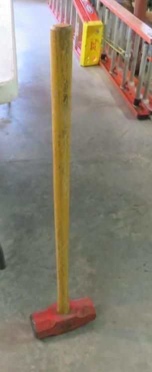 A red sledgehammer with a wooden handle.