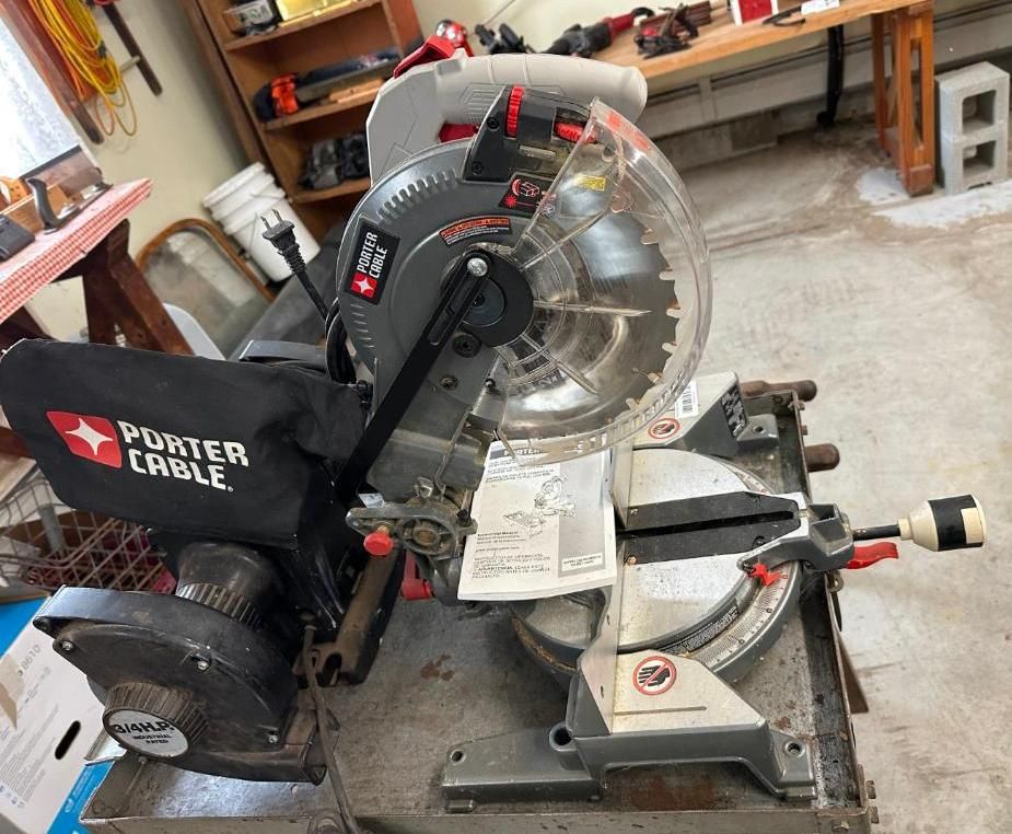 Porter-Cable miter saw with a blade guard and dust bag, on a work surface.
