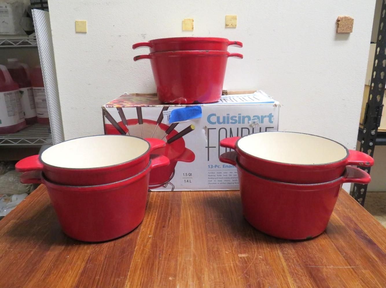 Red Cuisinart fondue pots on a wooden surface.