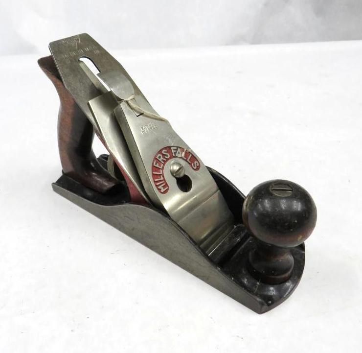 A Millers Falls hand plane on a white surface, with a wooden handle and knob.