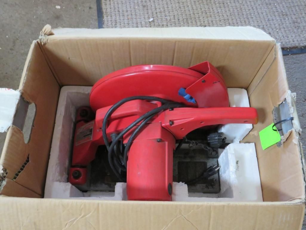Red power tool in a cardboard box, packed with white foam.