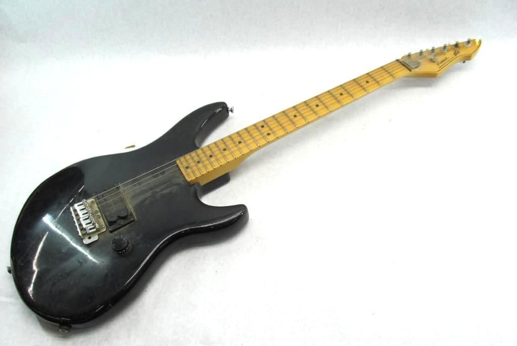 Black electric guitar on a white background.