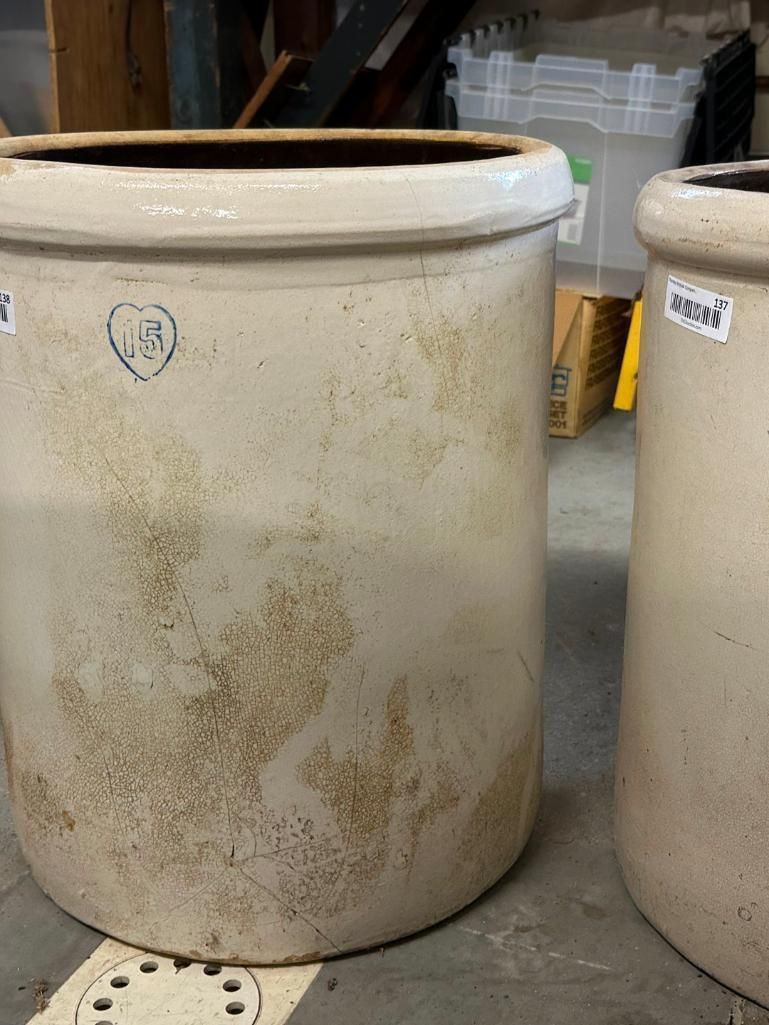 Two antique stoneware crocks with brown markings; one has a blue heart.