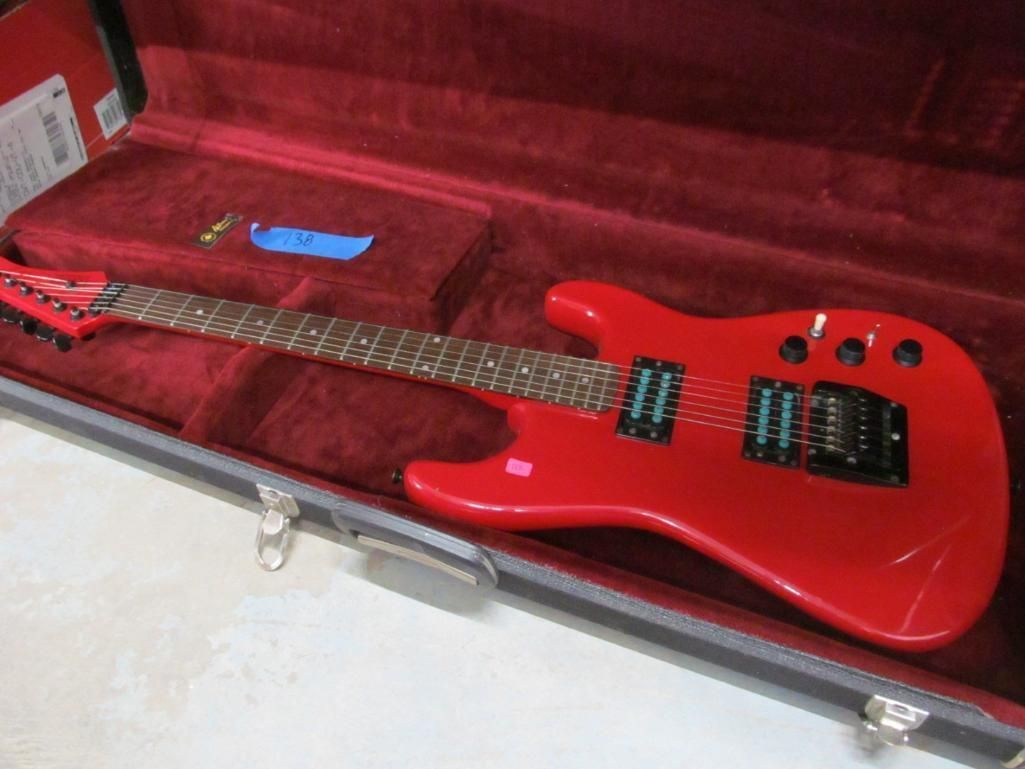 Red electric guitar in a velvet-lined case.