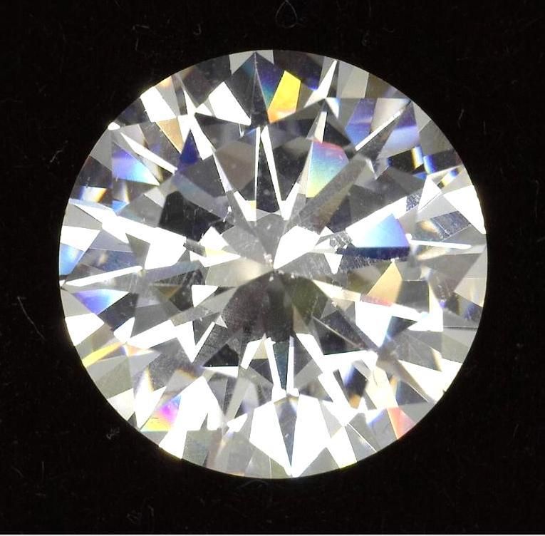 Close-up view of a round, brilliant-cut diamond with facets reflecting light against a black background.