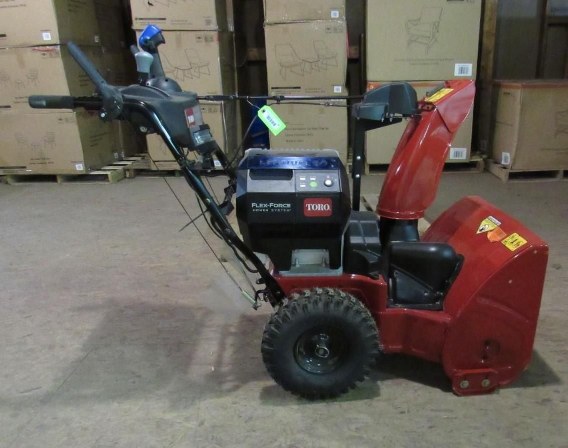 Red and black Toro snowblower with a chute, black tires, and control panel.