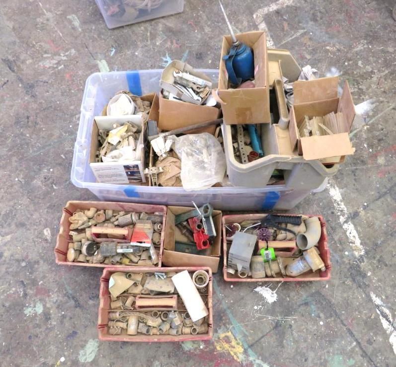 Boxes of hardware and craft supplies on a floor.