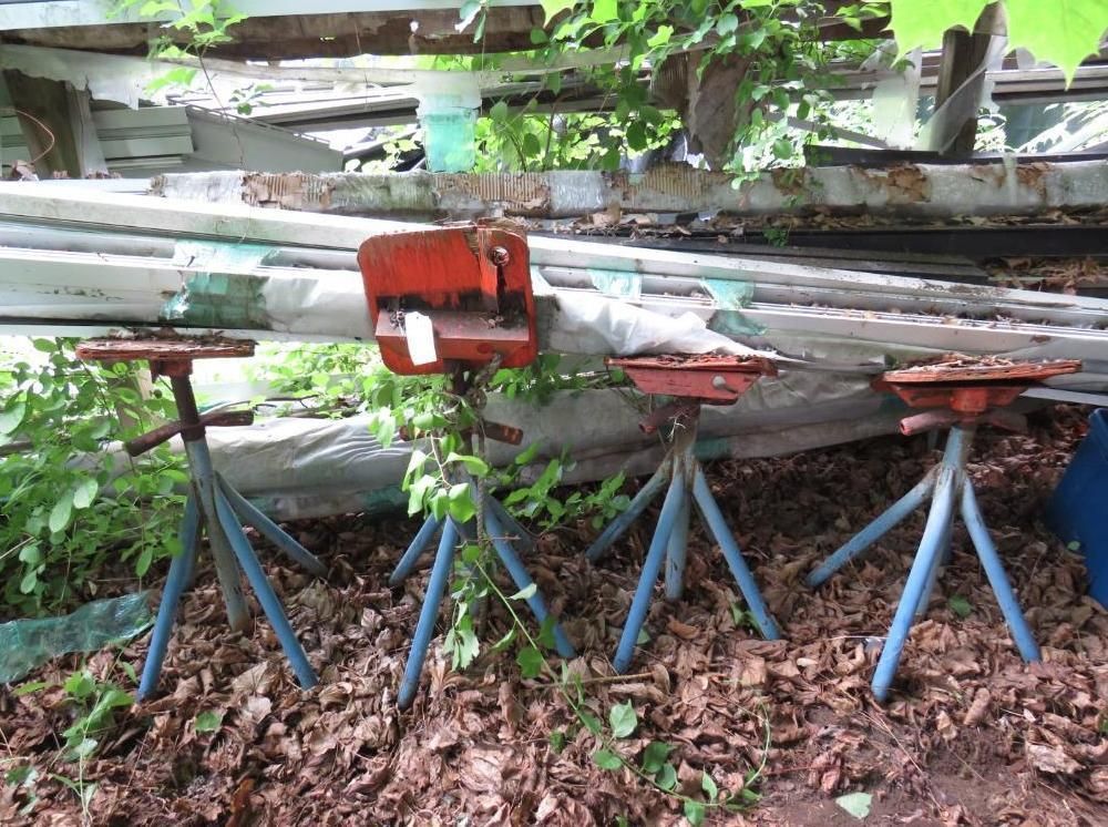 Three metal jack stands with blue legs and red tops.
