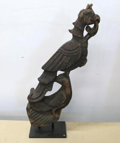 Wooden bird sculpture on black stand; bird perched above another.