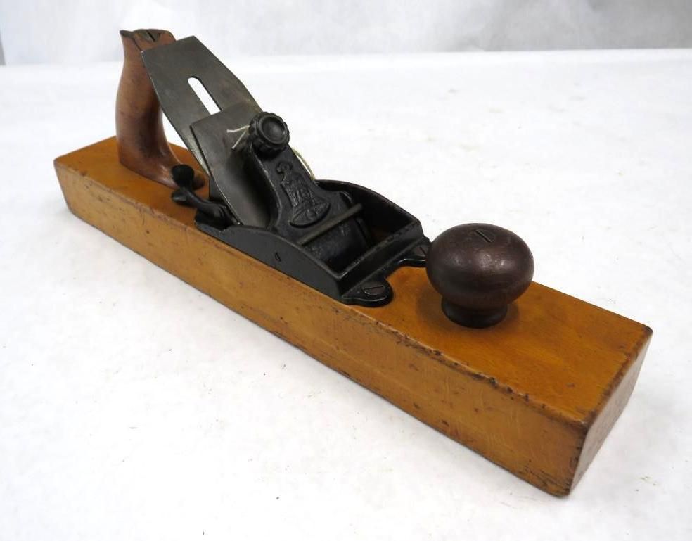 Wooden hand plane with a dark iron blade and handle.