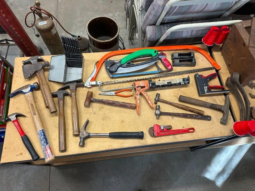 Workbench with various hand tools, including hammers, saws, and pliers.