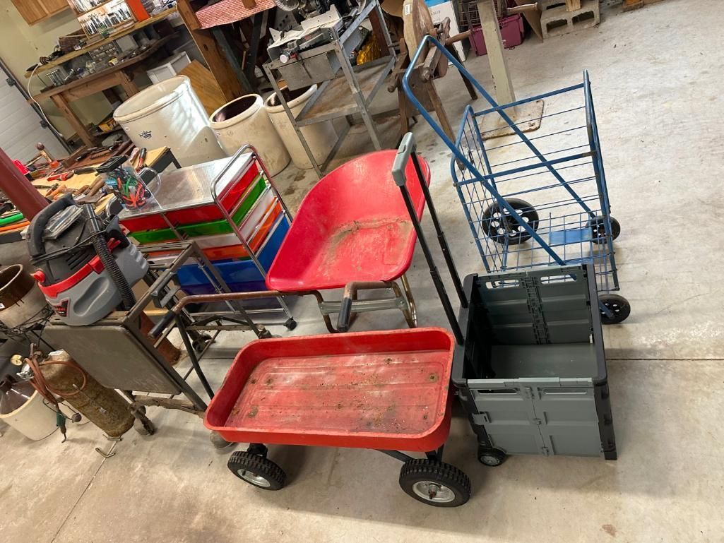 Various carts and containers in a room with a workbench and other items.