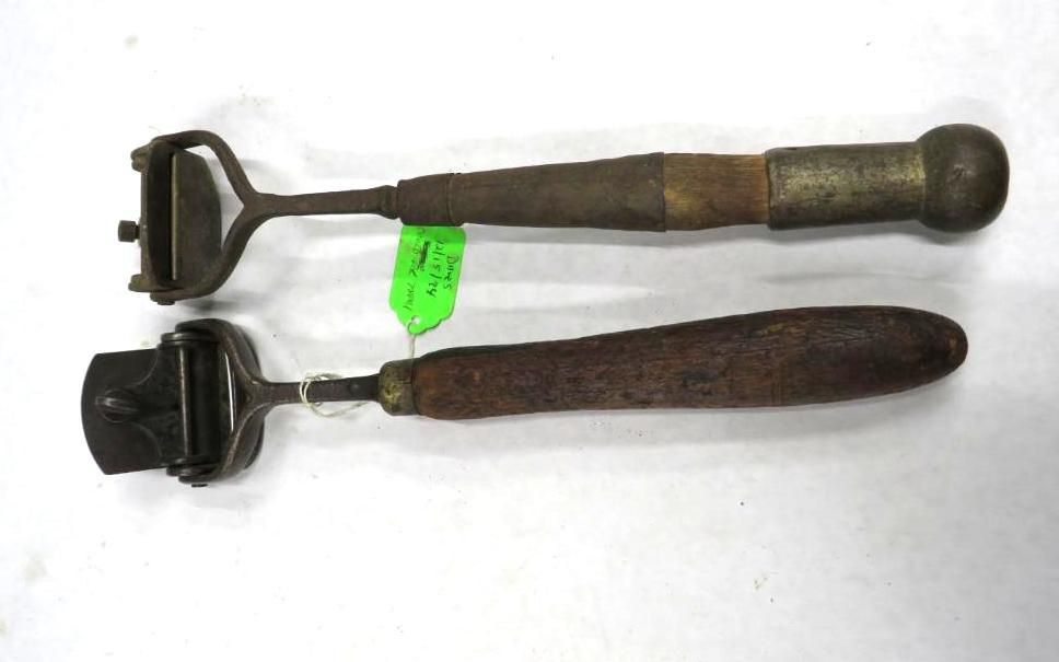Two antique leatherworking tools with wooden handles and metal heads.
