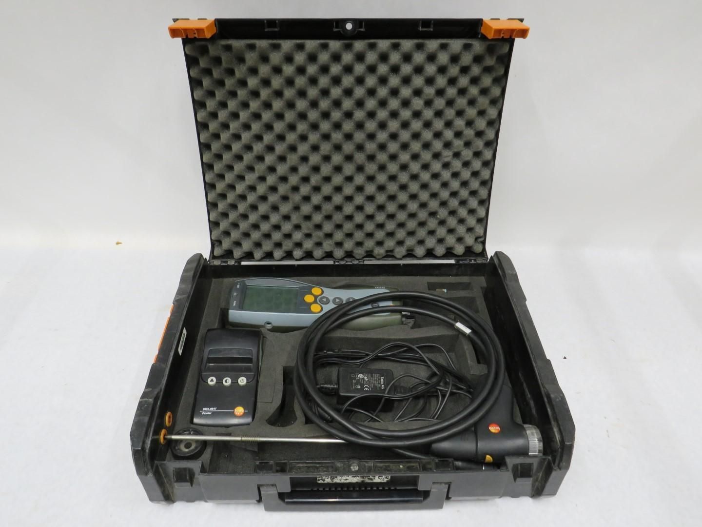 Black toolbox open, containing testing equipment and cables.