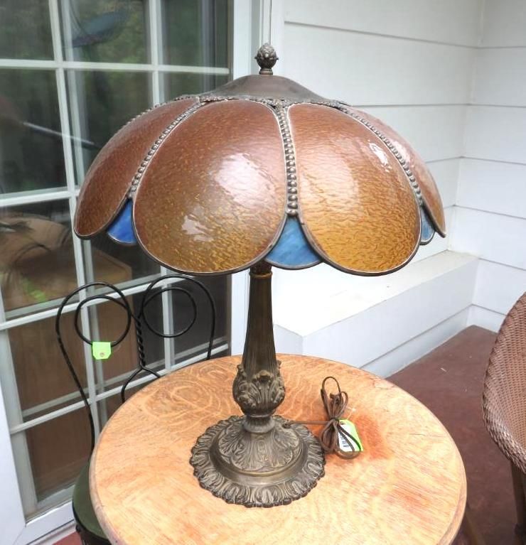 A table lamp with a copper and blue stained-glass shade.