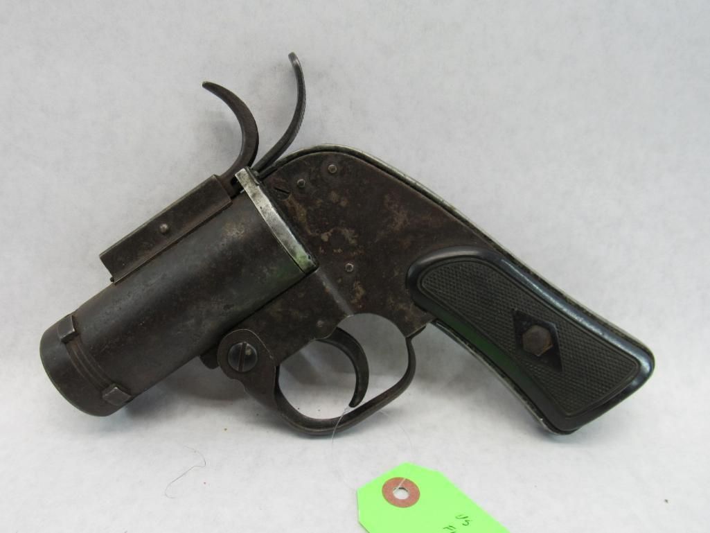 Dark flare gun with a black grip and trigger, against a neutral background.