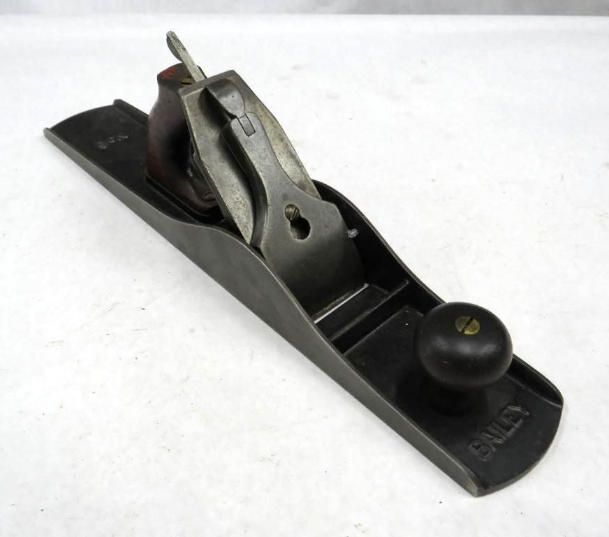 Dark metal hand plane with wooden handle and knob; 