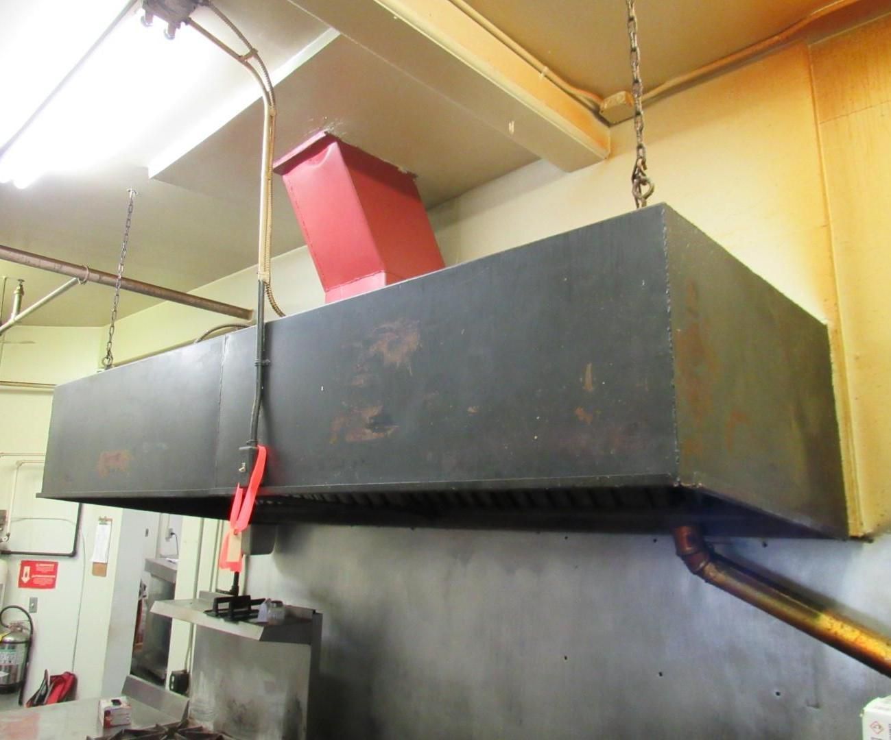 Industrial kitchen exhaust hood with red ductwork, hanging from ceiling.
